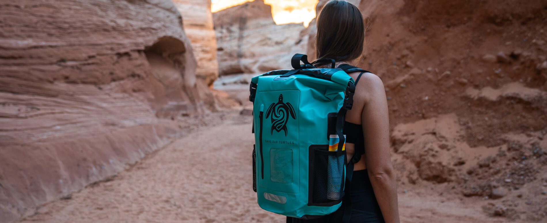 Woman with a teal roll top waterproof backpack